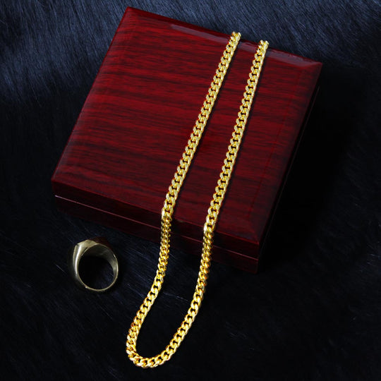 Cuban link chain for boyfriend displayed on a wooden box with a ring.