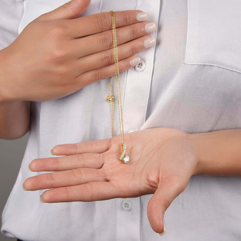 Woman holding the Alluring Beauty Necklace, a sentimental birthday jewelry gift for her, showcasing its elegance and charm.