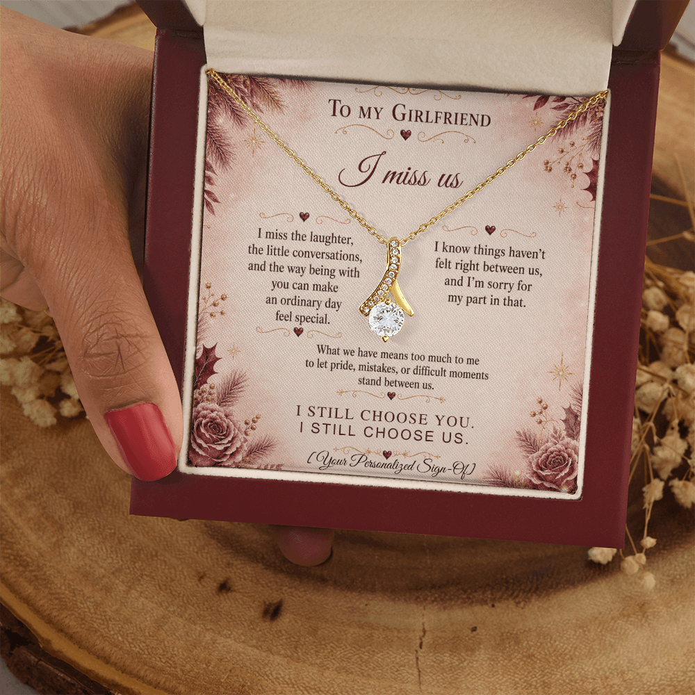 A hand holding a jewelry box with an Alluring Beauty Necklace and a heartfelt message for an apology gift for girlfriend.