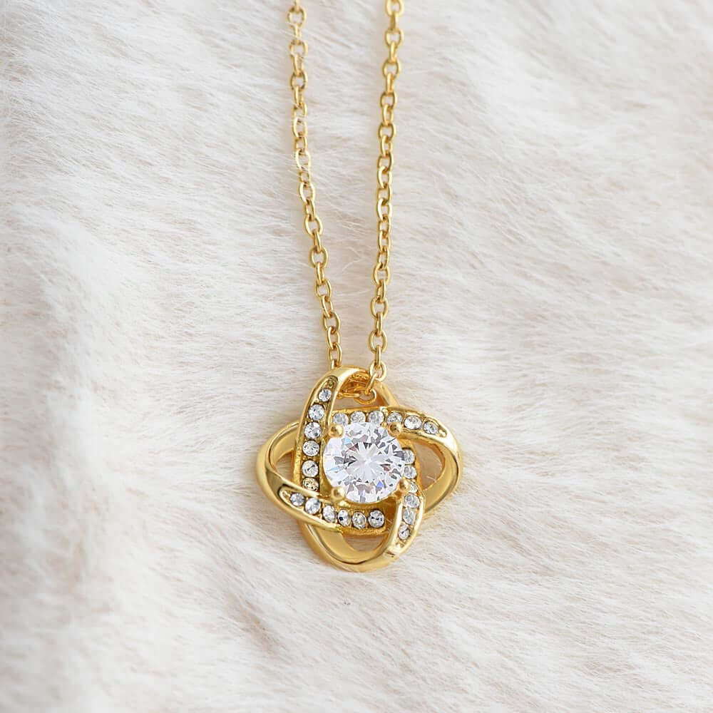 Interlocking knot keepsake milestone gift for her, featuring a gold necklace with a sparkling crystal.