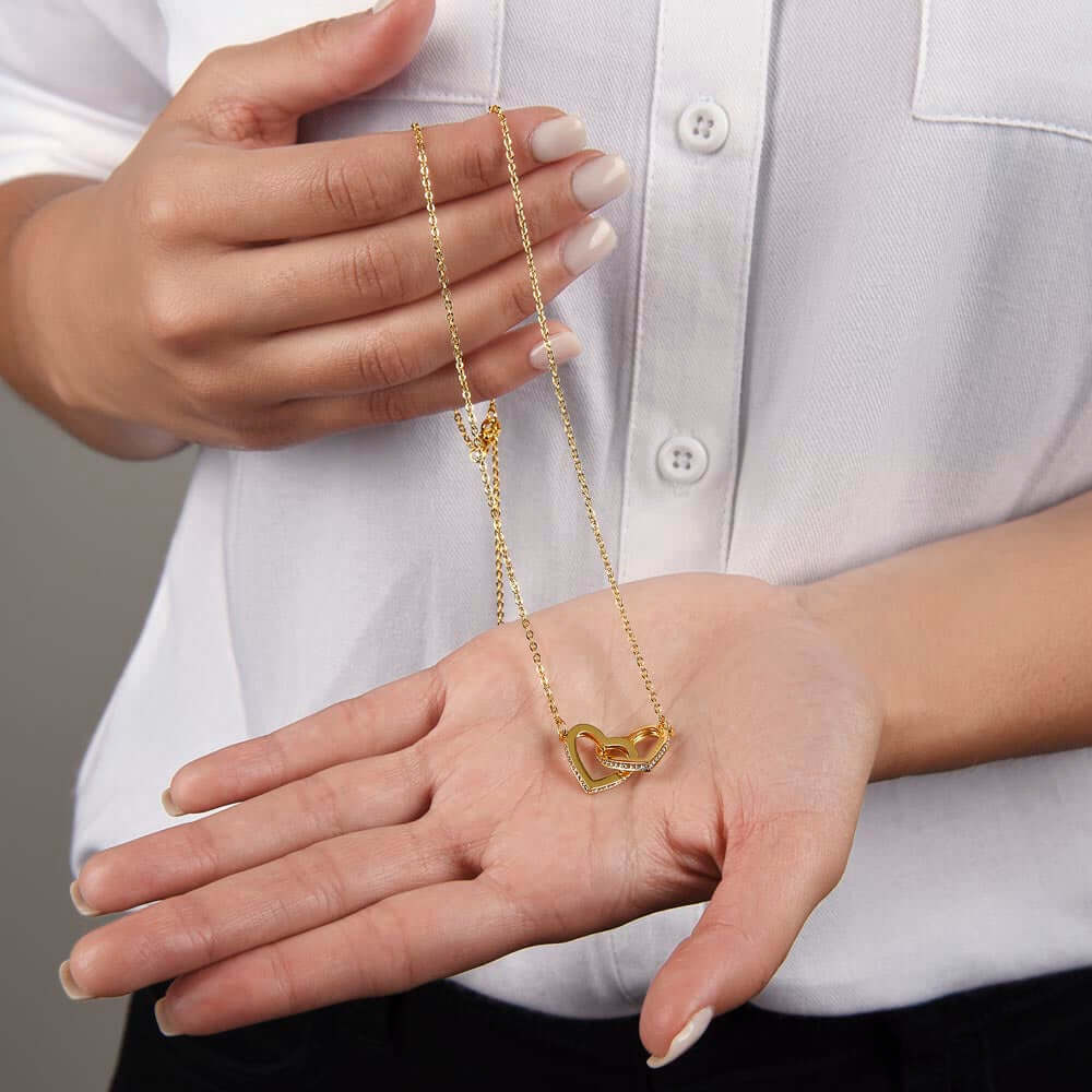 Luxury soulmate connection jewelry parents to daughter keepsake displayed in hand with interlocking hearts charm.