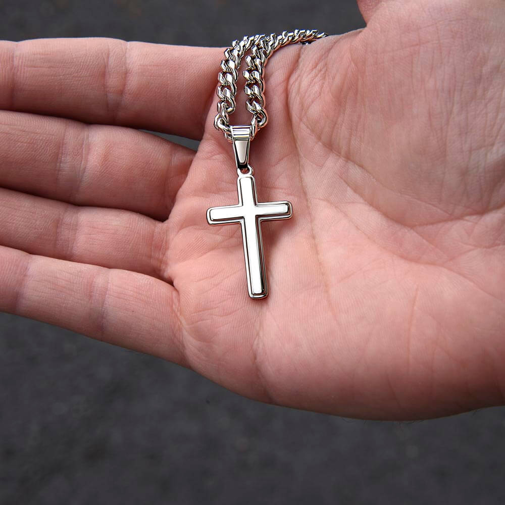 Meaningful milestone gift for loved ones: silver cross necklace held in a hand.